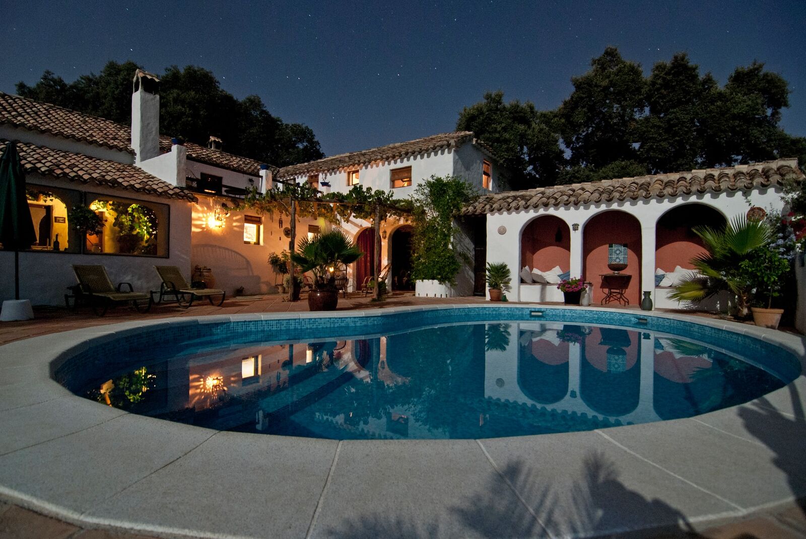Villa méditerranéenne illuminée au crépuscule, piscine et arcades, Saint-Tropez